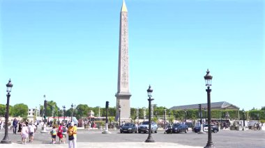 26 Temmuz 2025 'te Paris' teki Place de la Concorde 'da insanlar Luxor Obelisk' te yürüyor ve araba sürüyor.