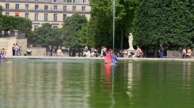 Oyuncak yelkenliler ve insanlar 26 Temmuz 2025 'te Tuileries Garden Paris' teki gölette dinleniyorlar.