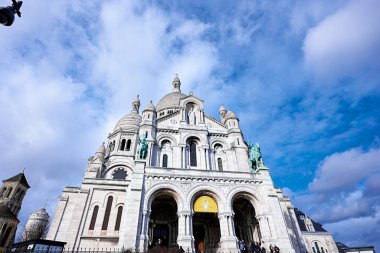 Montmartre, Paris, Fransa 'daki Sacre Coeur Bazilikası' nın 22 Şubat 2025 'teki parlak mavi gökyüzü ve bulutları.