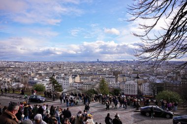 İnsanlar güneşli bir şubat gününde Paris 'in ufuk çizgisine bakan Montmartre terasında toplandılar.