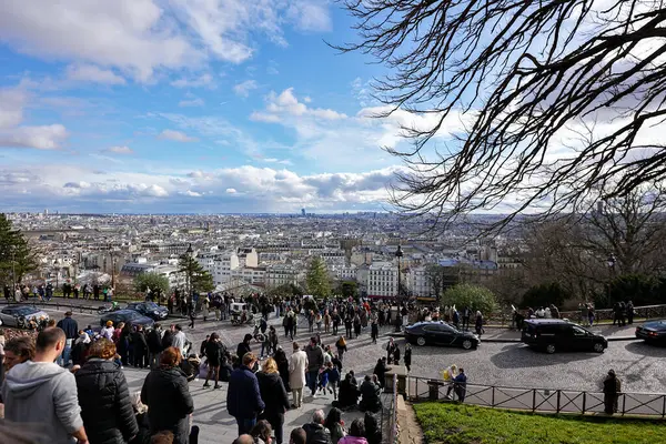 22 Şubat 2025 'te Montmartre' daki Sacre Coeur tepesinden Paris 'in panoramik manzarasının keyfini çıkaran bir kalabalık.