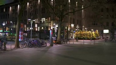 7 Ocak 2025 'te Hanover Almanya' da çekilen sessiz bir şehir caddesinde aydınlatılmış Noel ağaçları ve bisikletler. 