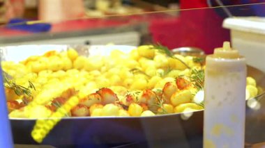 Çeşitli ızgara sosisleri yakın çekim bir yemek tezgahında hazırlanan bir tepside. Sıcak ışıklandırmada çeşitli etlerle sulu sokak yemekleri sahnesi 