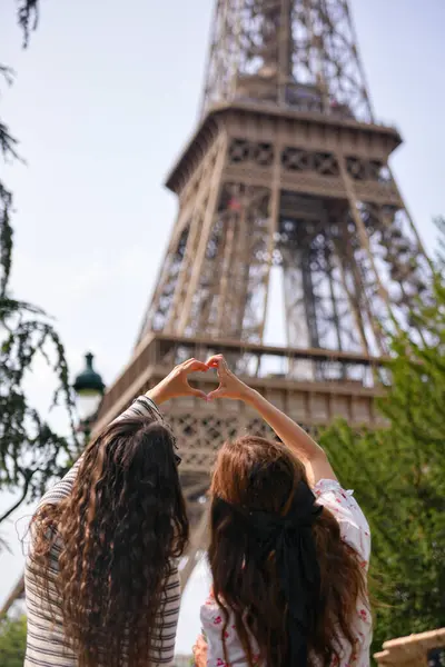 Paris 'te Eyfel Kulesi' nin önünde kalp hareketi yapan kadınlar