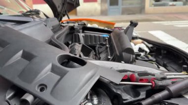 Motor bileşenlerini ve araçları tamir sırasında açık araba kaputunun altında gösteren videoyu kapat 
