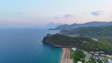 Çam tepeleri ve huzurlu koyları olan manzaralı sahil beldesi.