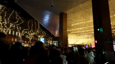 Paris 2 Aralık 2023 'te insanlar Lafayette yakınlarındaki altın tatil ışıklarına hayran kaldılar.