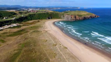Çimenli kum tepeleri ve sahil yollarıyla kumsal manzarası