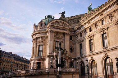 Paris, Fransa 'daki Palais Garnier Opera Binası' nın güzel yüzü. Klasik mimariyle tarihi eser ve kültürel cazibe, akşam güneşiyle aydınlatılıyor..