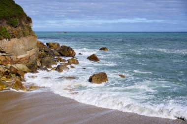 Kayalıkları ve mavi denizi olan deniz manzarası