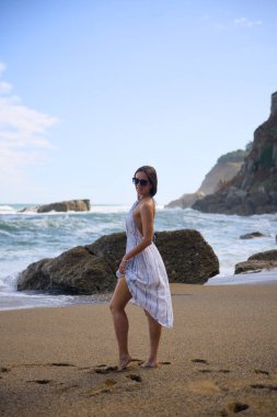 Okyanus manzaralı kumlu plajda duran kadın model.