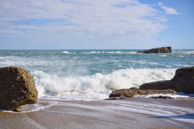 Kum ve köpüklü sörflü deniz burnu