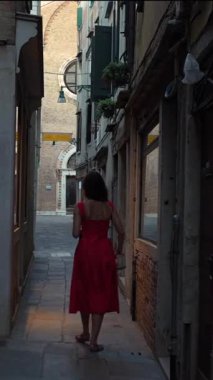 Kırmızı yaz elbiseli turist Venedik İtalya 'nın tarihi geçidini keşfediyor.