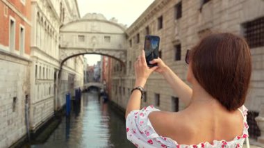 Venedik yaz gezisinde İç Çekiş Köprüsü 'nün fotoğrafını çeken bir turist.
