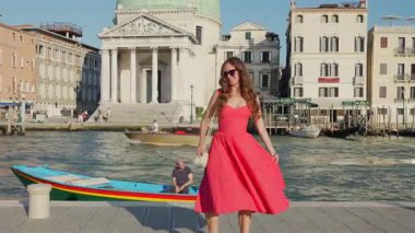Venedik İtalya 29 Haziran 2025 Kırmızı elbiseli kadın Büyük Kanal 'da yürüyor