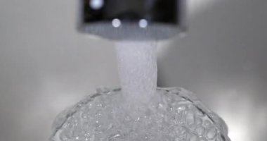 Musluktan akan su ve bir bardak suyu taşıran, gerçek zamanlı 4K