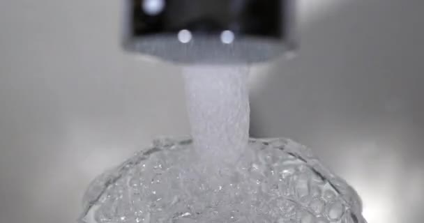 从水龙头流出的水 并使一杯水溢出 实时4K — 图库视频影像