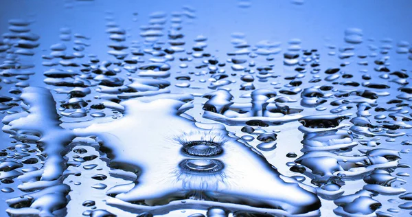 Droppe Vatten Faller Vatten Mot Blå Bakgrund — Stockfoto