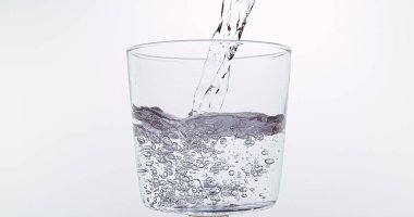 Beyaz Arkaplan 'a karşı bardağa su dökülüyor