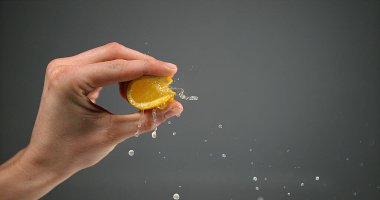 Siyah Arkaplan Karşısında Portakal Sıkan Kadın Eli