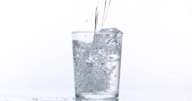 Beyaz Arkaplan 'a karşı bardağa su dökülüyor