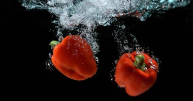 Red Sweet Pepper, capsicum annum, Sebze Kara Arkaplan 'a karşı suya düşüyor.