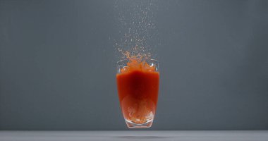 Bir bardak domates suyu düşüyor.