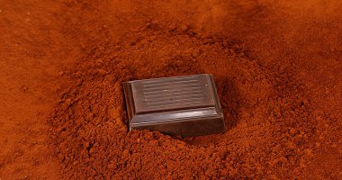 Siyah Çikolata Tableti Kara Çikolata Tozu 'nun üzerine düşüyor.