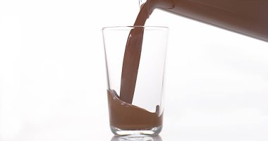 Çikolata Beyaz Arkaplan 'a karşı bir bardağa dökülüyor