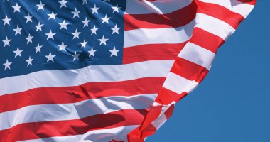 Mavi gökyüzünde dalgalanan Amerikan bayrağı