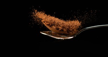 Nutmeg, Myristica parçaları, Kara Arkaplan 'a karşı kaşıktan düşen toz.