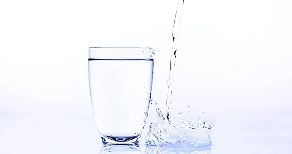Agua Que Vierte Vidrio Contra Fondo Blanco —  Fotos de Stock
