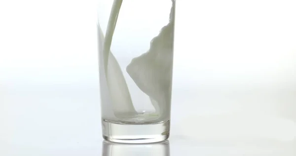 在白色背景下 牛奶倒入玻璃杯 — 图库照片