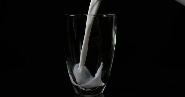 Melk Wordt Gegoten Glas Tegen Zwarte Achtergrond — Stockfoto