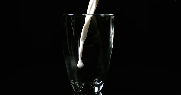 Молоко Вливають Скло Чорному Тлі — стокове фото