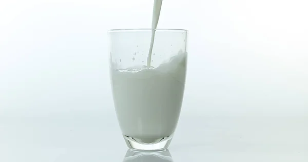Γάλα Που Χύνεται Στο Γυαλί Λευκό Φόντο — Φωτογραφία Αρχείου