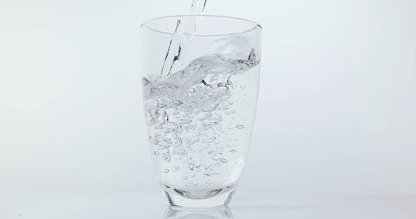 Water Wordt Gegoten Glas Tegen Witte Achtergrond — Stockfoto
