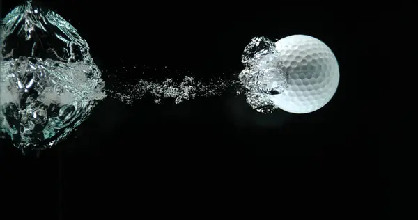 高尔夫球在黑色背景下落入水中 — 图库照片