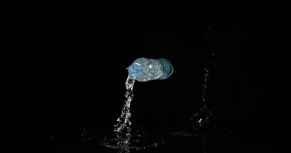 Plastikflasche Fällt Und Spritzt Vor Schwarzem Hintergrund — Stockfoto