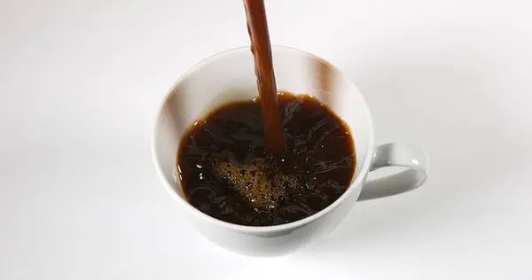 Kaffee Der Vor Weißem Hintergrund Eine Tasse Gegossen Wird — Stockfoto