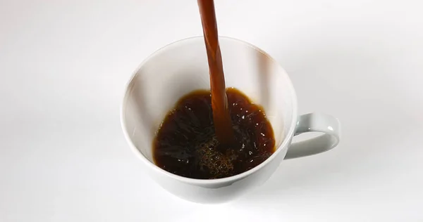 Koffie Wordt Gegoten Een Beker Tegen Witte Achtergrond — Stockfoto