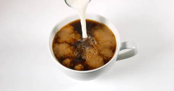 Milch Eine Tasse Kaffee Vor Weißem Hintergrund Gegossen — Stockfoto