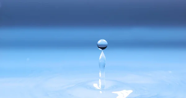 Капля Воды Падает Воду Голубом Фоне — стоковое фото