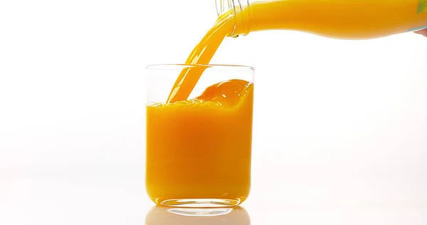 Orangensaft Wird Vor Weißem Hintergrund Ins Glas Gegossen — Stockfoto