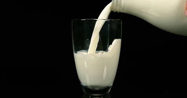 Mjölk Hälls Glas Mot Svart Bakgrund — Stockfoto