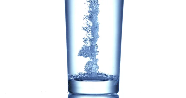 Agua Que Vierte Vidrio Contra Fondo Blanco — Foto de Stock