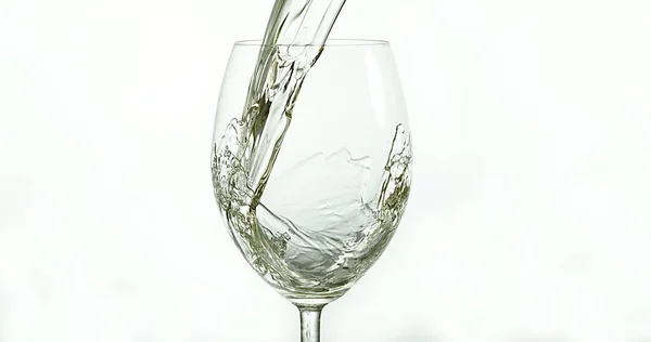 白いワインは白い背景に対してガラスに注がれます — ストック写真