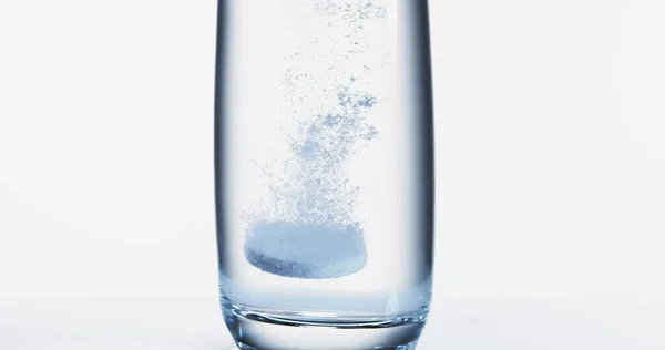 Tabletler Beyaz Arkaplan Karşı Bir Bardak Suya Düşüp Çözülüyor — Stok fotoğraf