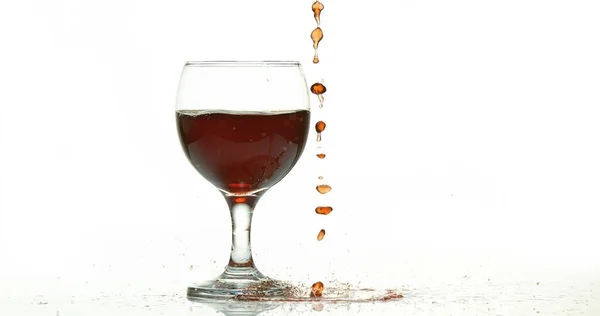 Красное Вино Выливается Стекло Белом Фоне — стоковое фото