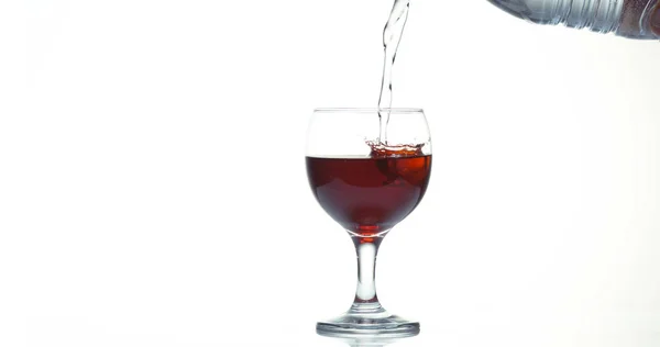 Κόκκινο Κρασί Που Χύνεται Στο Γυαλί Λευκό Φόντο — Φωτογραφία Αρχείου